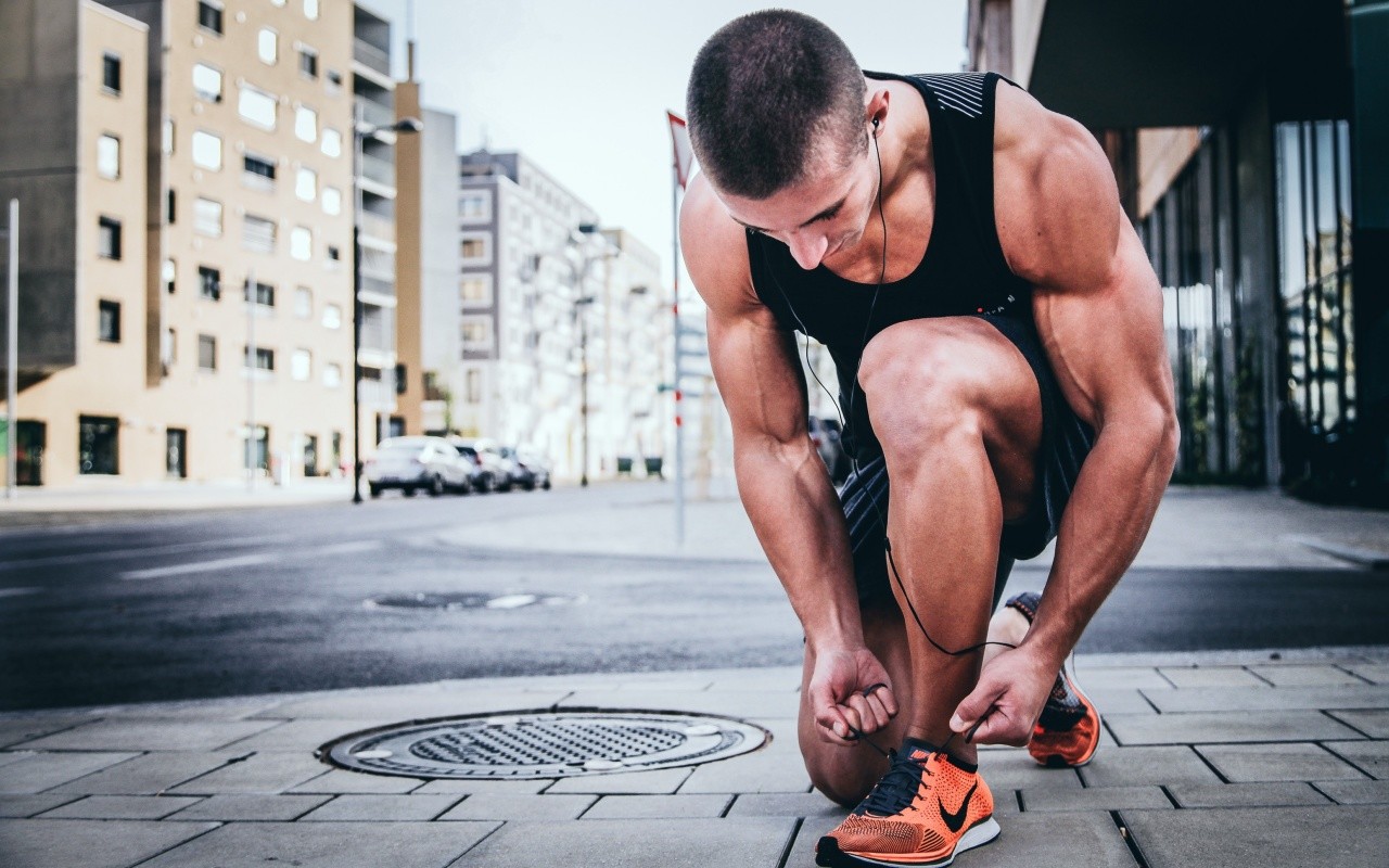 runner si allaccia le scarpe su strada