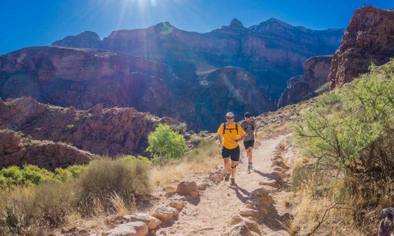 2 runner corrono su strada sterrata immersi nella natura