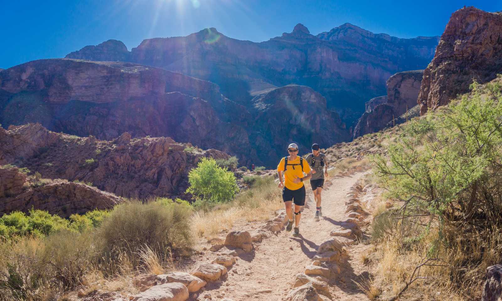 2 runner corrono su strada sterrata immersi nella natura