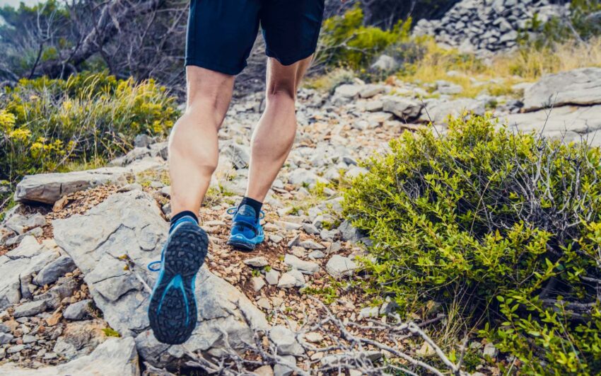 runner con scarpe da trail corre su sterrato in montagna