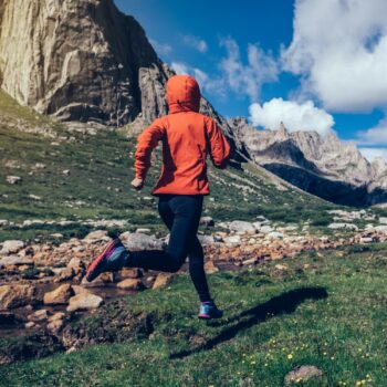 woman trail runner running on beautiful mountains
