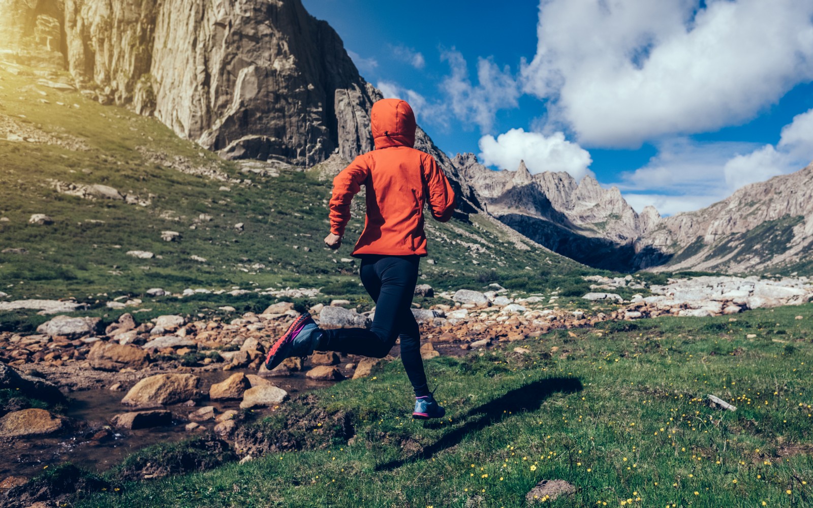 woman trail runner running on beautiful mountains